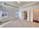 Large bedroom with neutral carpet and tray ceiling detail at 2929 Rambler Dr, Loganville, GA 30052