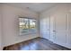 Bright bedroom with wood-look flooring, large window with neighborhood view, and white doors at 2929 Rambler Dr, Loganville, GA 30052