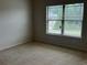 Bedroom featuring a large window allowing natural light, and neutral colored walls and carpet at 4482 Ridge Mill Ne Ter, Douglasville, GA 30135