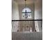 Upstairs hallway featuring decorative iron railing and large arched window with natural light at 4482 Ridge Mill Ne Ter, Douglasville, GA 30135