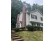 Multi-level home exterior with brick accents, black shutters, and green landscaping at 5425 Village Green Sq, Norcross, GA 30093