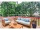 Outdoor deck with outdoor seating and view of treed backyard at 930 Cedar Bluff Sw Trl, Lilburn, GA 30047