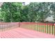 Wooden deck featuring a red-painted railing and views of the backyard at 930 Cedar Bluff Sw Trl, Lilburn, GA 30047