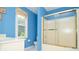 Bathroom featuring blue walls, white vanity, and glass door shower at 930 Cedar Bluff Sw Trl, Lilburn, GA 30047