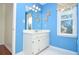 Bathroom featuring blue walls, a white vanity, and a window with tree view at 930 Cedar Bluff Sw Trl, Lilburn, GA 30047