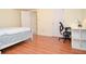 Bedroom with wood flooring, a bed, a desk, and access to bathroom at 930 Cedar Bluff Sw Trl, Lilburn, GA 30047