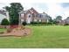 Two-story brick home with a well-manicured lawn and mature landscaping at 930 Cedar Bluff Sw Trl, Lilburn, GA 30047