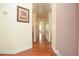 Inviting hallway with hardwood floors, neutral paint, and decorative artwork leads to various rooms at 930 Cedar Bluff Sw Trl, Lilburn, GA 30047