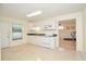Bright kitchen with white cabinets and an adjacent rec room at 930 Cedar Bluff Sw Trl, Lilburn, GA 30047