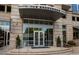 Exterior view of the Brookwood building entrance with glass doors and landscaped planters at 1820 Peachtree St # 1607, Atlanta, GA 30309