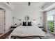 A stylish main bedroom features a king bed, modern lighting, and large windows overlooking a green view at 1820 Peachtree St # 1607, Atlanta, GA 30309