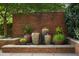 Peaceful garden water feature with potted plants against a brick wall adding tranquility to the outdoor space at 1820 Peachtree St # 1607, Atlanta, GA 30309