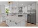 A modern kitchen featuring white cabinets, stainless steel appliances, and a large island with quartz countertops at 2517 Hampton Park Ct, Marietta, GA 30062