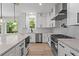 A modern kitchen featuring white cabinets, stainless steel appliances, and a large island with quartz countertops at 2517 Hampton Park Ct, Marietta, GA 30062