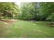 Expansive backyard with lush green grass, mature trees, and natural surroundings at 5670 Lanny Dr, Powder Springs, GA 30127
