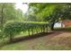 Backyard featuring a unique overhead garden structure and lush greenery at 5670 Lanny Dr, Powder Springs, GA 30127