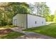 Large white barn with a roll up door, side door, concrete driveway and manicured lawn at 5670 Lanny Dr, Powder Springs, GA 30127