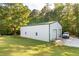 Large white barn with multiple bays, concrete pad, and manicured lawn at 5670 Lanny Dr, Powder Springs, GA 30127