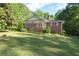 Charming brick home with a welcoming screened-in porch and lush, green lawn at 5670 Lanny Dr, Powder Springs, GA 30127