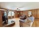 Bright living room with hardwood floors, fireplace, wood paneling, and cozy seating area at 5670 Lanny Dr, Powder Springs, GA 30127