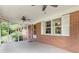 Screened porch with ceiling fans, brick wall, door, and view of surrounding greenery at 5670 Lanny Dr, Powder Springs, GA 30127