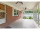 Screened-in porch with ceiling fans, brick wall, and exterior door to the backyard at 5670 Lanny Dr, Powder Springs, GA 30127