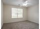 Neutral bedroom with a ceiling fan, carpeted floors, and a large window at 1321 Waterton Trl, Douglasville, GA 30134