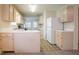Bright kitchen featuring tan cabinetry, white countertop, a center island, and a white refrigerator at 1321 Waterton Trl, Douglasville, GA 30134