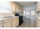Functional kitchen features tan cabinetry, a black gas range, and a double stainless steel sink at 1321 Waterton Trl, Douglasville, GA 30134