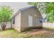 Charming rear exterior of a one-story home with neutral siding, white door, and tidy landscaping, set against a treed backyard at 1321 Waterton Trl, Douglasville, GA 30134