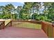 View from the spacious wooden deck overlooking the lush backyard, surrounded by mature trees and a fenced perimeter at 4963 Kingsbridge Ct, Powder Springs, GA 30127