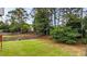 Expansive backyard featuring a well-manicured lawn, mature trees, and a wooden fence for privacy at 4963 Kingsbridge Ct, Powder Springs, GA 30127