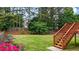 View from backyard deck down to the lush lawn with surrounding trees and landscaping at 4963 Kingsbridge Ct, Powder Springs, GA 30127