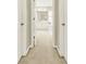 View through double doors to the bright, luxurious bathroom with white cabinets and a soaking tub at 4963 Kingsbridge Ct, Powder Springs, GA 30127