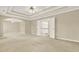 Spacious bedroom with tray ceilings, ceiling fan and double doors leading to the ensuite bathroom at 4963 Kingsbridge Ct, Powder Springs, GA 30127