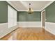 Well-lit dining room with hardwood floors, wainscoting, and neutral color scheme at 4963 Kingsbridge Ct, Powder Springs, GA 30127