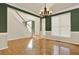 Elegant dining room with hardwood floors, wainscoting, and a modern chandelier at 4963 Kingsbridge Ct, Powder Springs, GA 30127