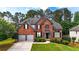 Charming brick two-story home with a manicured lawn and two-car garage, nestled among lush trees at 4963 Kingsbridge Ct, Powder Springs, GA 30127