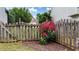 Wooden fence surrounds garden with mulch landscaping and a flower bush in bloom at 4963 Kingsbridge Ct, Powder Springs, GA 30127