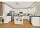 Spacious kitchen featuring white cabinets, a central island, stainless steel appliances and hardwood floors at 4963 Kingsbridge Ct, Powder Springs, GA 30127