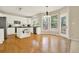 Open kitchen with white cabinets, stainless steel appliances, hardwood floors and large windows at 4963 Kingsbridge Ct, Powder Springs, GA 30127
