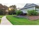 Well-maintained landscaping with retaining wall along a sidewalk and view of building at 4963 Kingsbridge Ct, Powder Springs, GA 30127