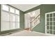 Spacious living room featuring large windows, neutral walls, and a staircase with wooden banister at 4963 Kingsbridge Ct, Powder Springs, GA 30127
