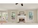 Cozy living room with a fireplace, large windows, and neutral-colored walls at 4963 Kingsbridge Ct, Powder Springs, GA 30127