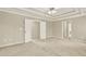 Large main bedroom with tray ceiling, ceiling fan and double-door entry, exuding comfort and style at 4963 Kingsbridge Ct, Powder Springs, GA 30127