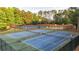 Aerial photo capturing multiple tennis courts with trees surrounding the gated tennis area at 4963 Kingsbridge Ct, Powder Springs, GA 30127