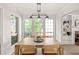 Light-filled dining room with large windows, modern chandelier, seating for six, and access to living spaces at 5999 Brookside Se Ln, Mableton, GA 30126