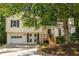 Charming split-level home with a well-manicured lawn, blue shutters, and an attached garage at 5999 Brookside Se Ln, Mableton, GA 30126