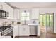 Bright kitchen with white cabinets, stainless steel appliances, and sliding glass door to the outside porch at 5999 Brookside Se Ln, Mableton, GA 30126