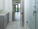 Bathroom featuring gray cabinets, white tile flooring, and a glass shower at 788 W Marietta Nw St # 311, Atlanta, GA 30318